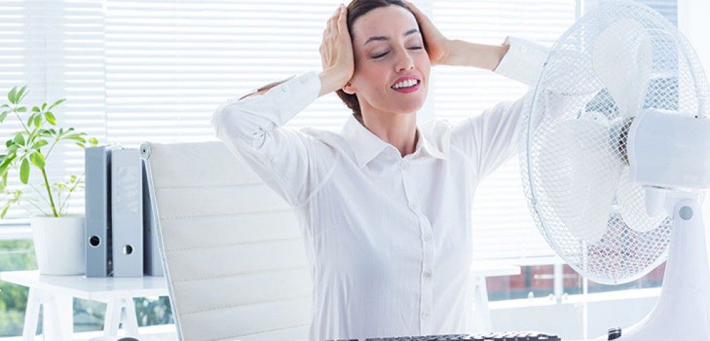 A Person Using a Fan To Stay Cool With An A/C System - Springbank Mechanical Toronto HVAC Company