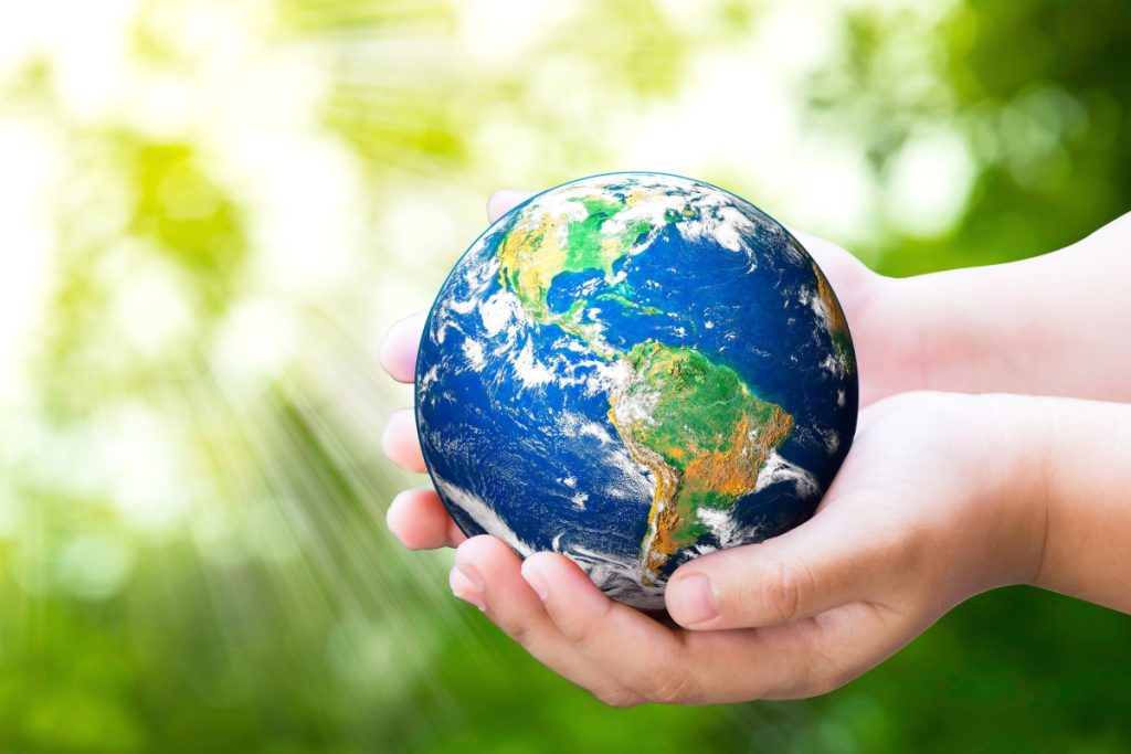 A Person Holding A Globe Indicating Reducing Emissions From A2L Refrigerants - Springbank Mechanical Toronto HVAC Company